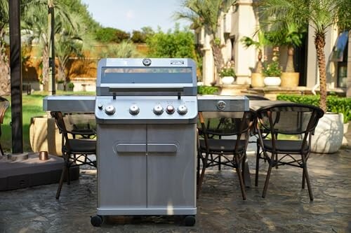 Outdoor gas grill with dining set in backyard.