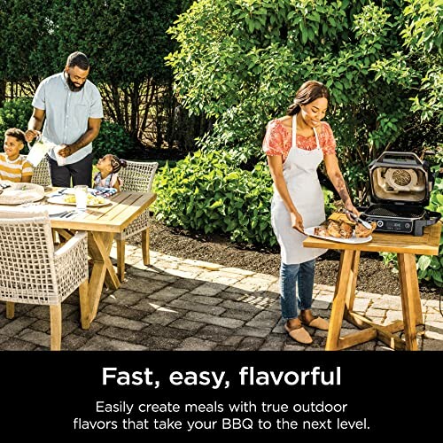 Family enjoying outdoor BBQ with grill and food on patio.