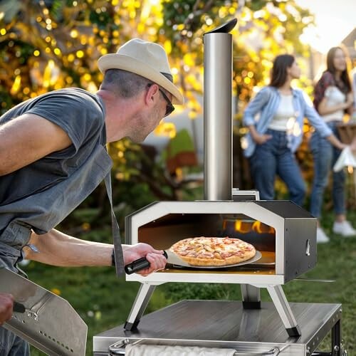 Man cooking pizza in outdoor oven with friends in background.