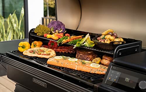 Outdoor grill with vegetables, meat, and salmon.