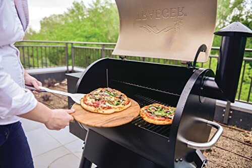 Person grilling pizza on outdoor grill.