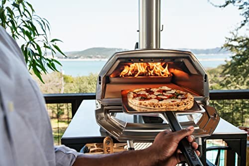 Person using an outdoor pizza oven with a view.