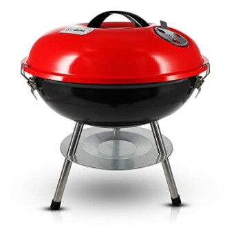 Portable charcoal grill with red lid and black bowl on tripod stand.